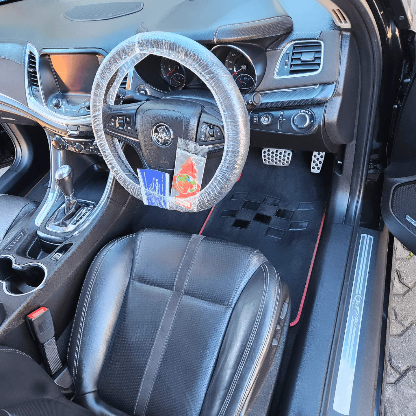 Detailed Holden Commodore interior with a protective steering wheel cover