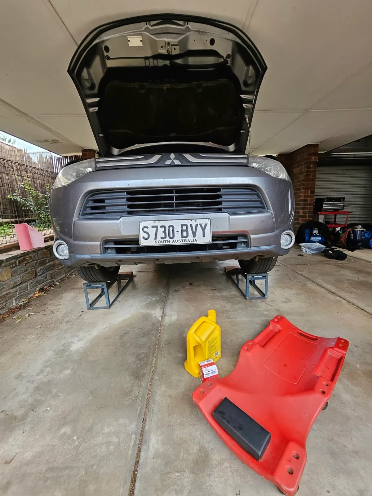 Mobile service underway with the bonnet raised in a driveway